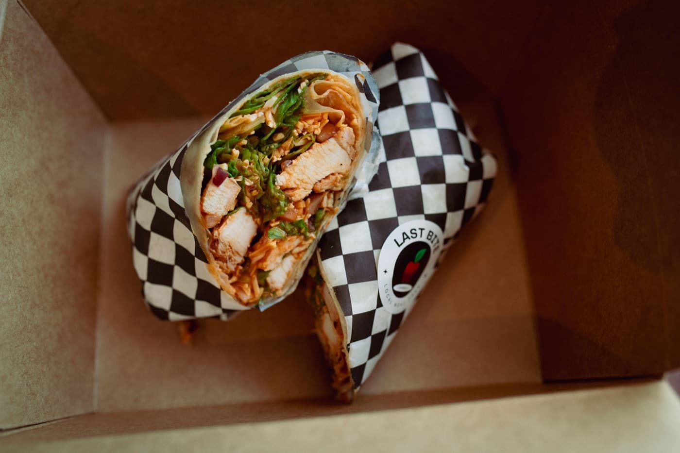 A freshly made Last Bite chicken wrap, boxed and ready for lunch